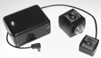 In the center a photocell with a flash shoe, on the left a photocell for a sync cable, on the right an accessory shoe with a tripod thread on the base and a sync cable.