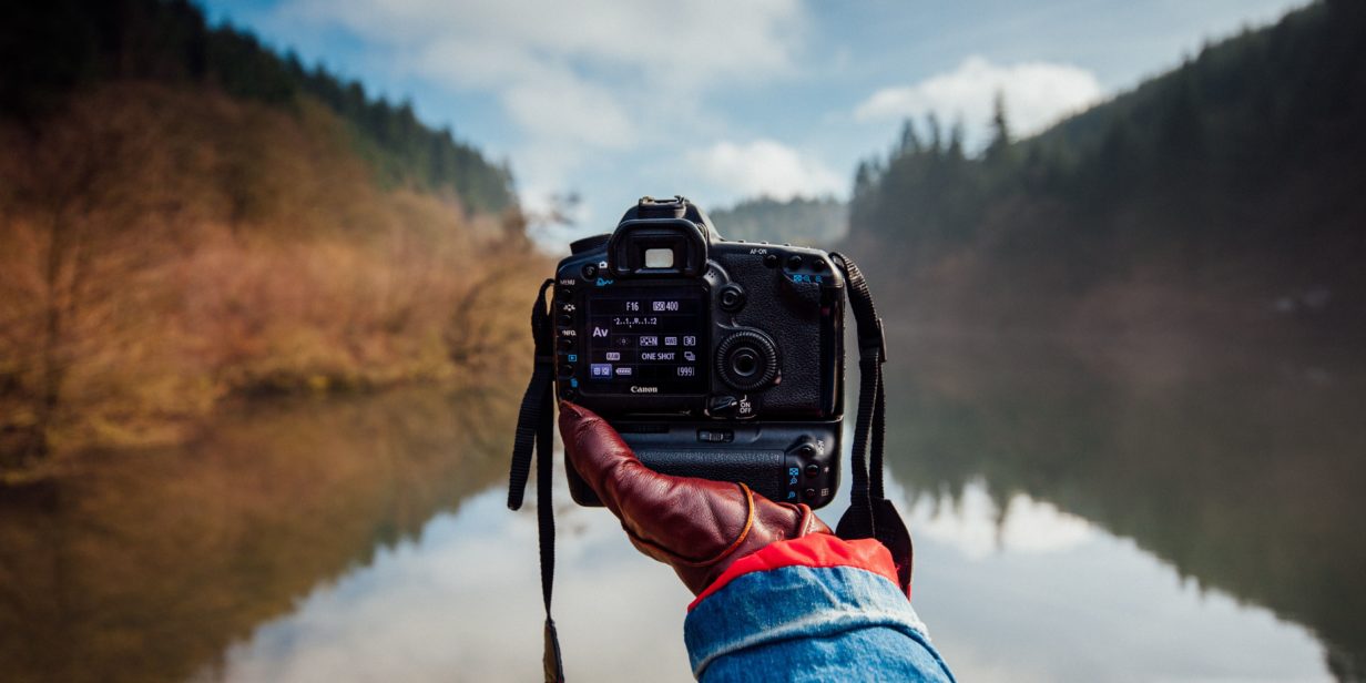 Cámara en mano de fotógrafo viajero