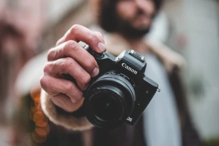 Fotografo con cámara en la mano