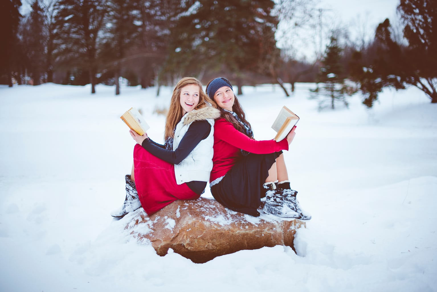 fotografía de dos chicas en la nieve con libros