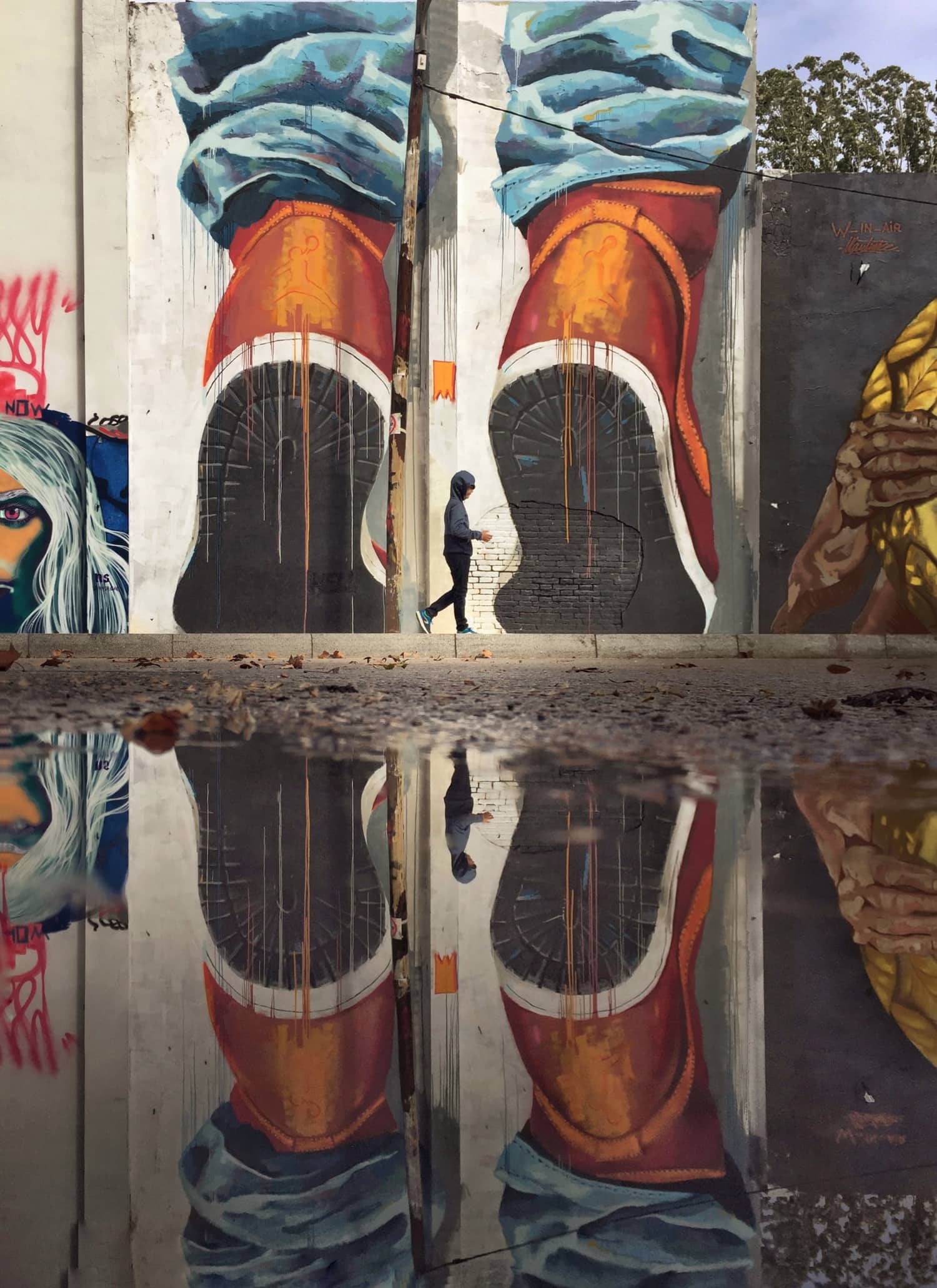 Fotografía callejera de un grafiti reflejado en un charco de agua Fotografía callejera de un grafiti reflejado en un charco de agua