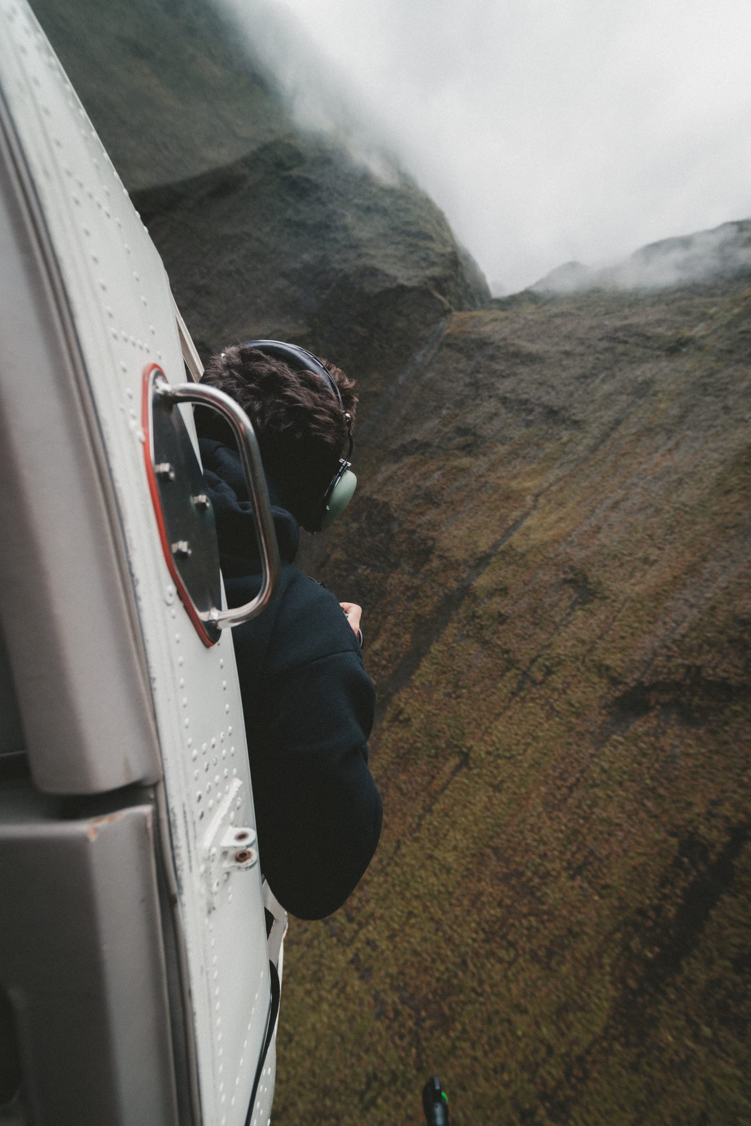 fotografía hombre asomando desde un helicóptero