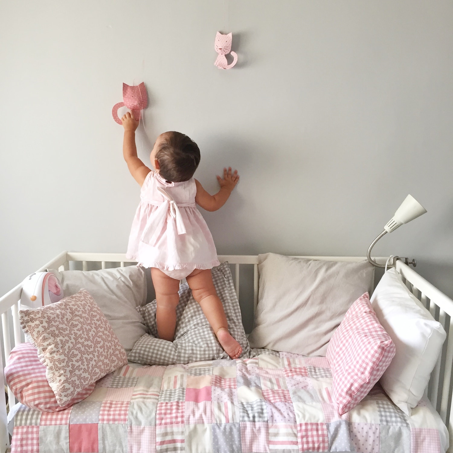 Photo of girl reaching for a wall decoration in diffused light