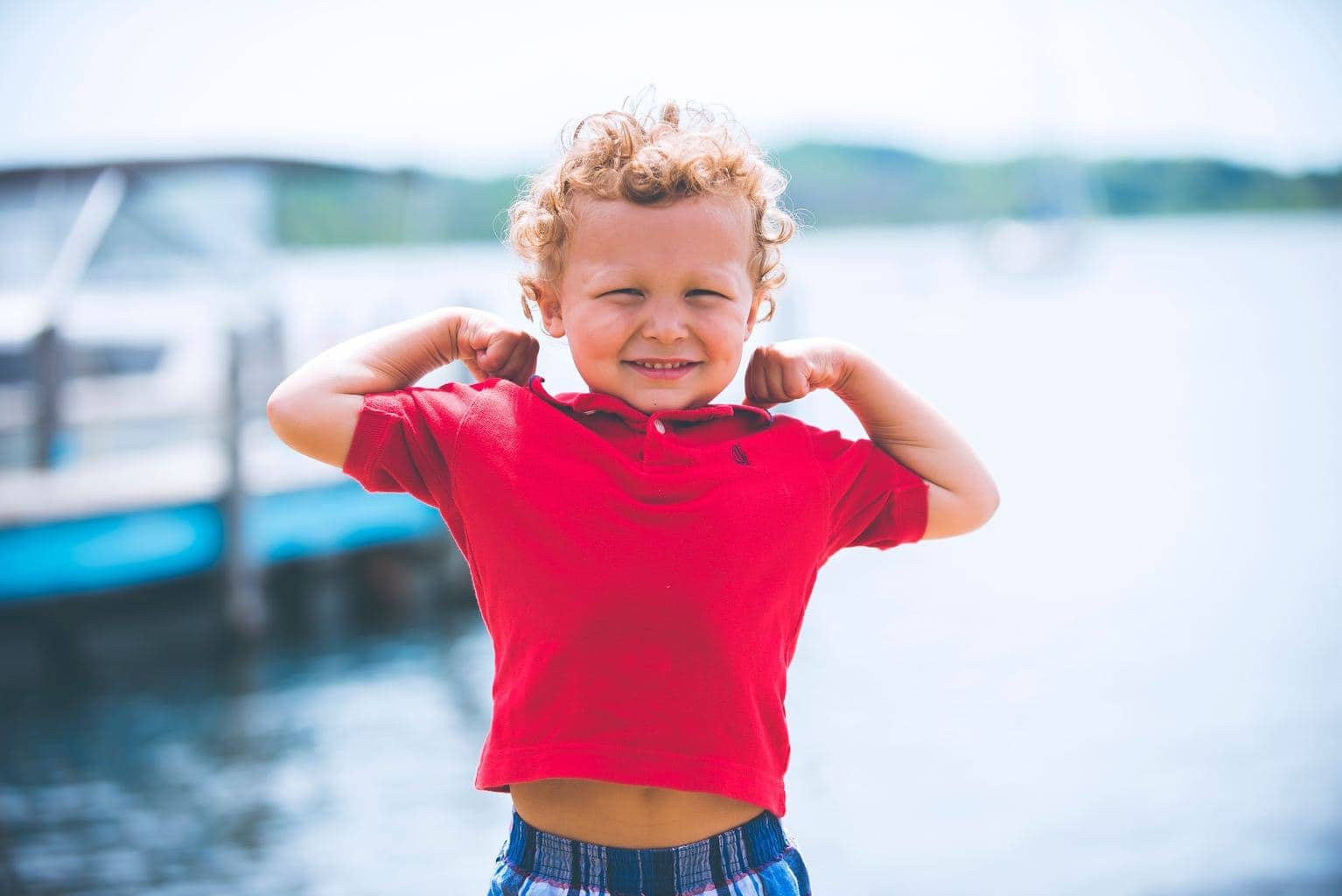 foto de niño con agua al fondo y camiseta roja