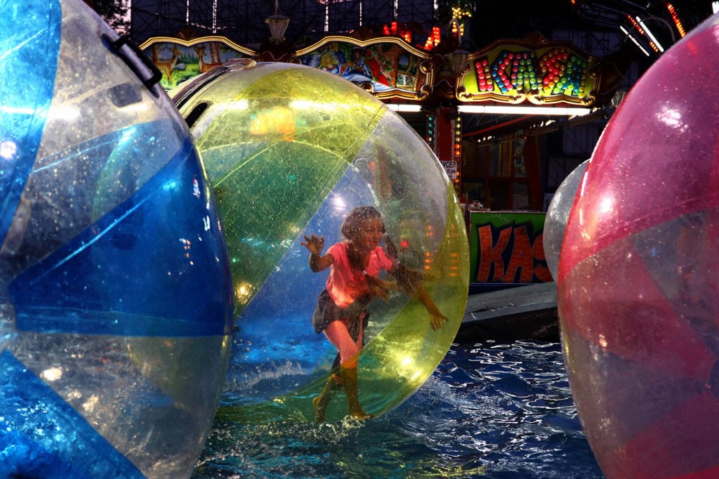 Fotografía de niña en feria nocturna tomada con cámara EVIL