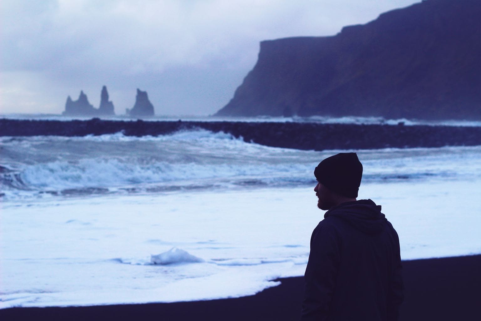 cold photograph of a man looking at the waves