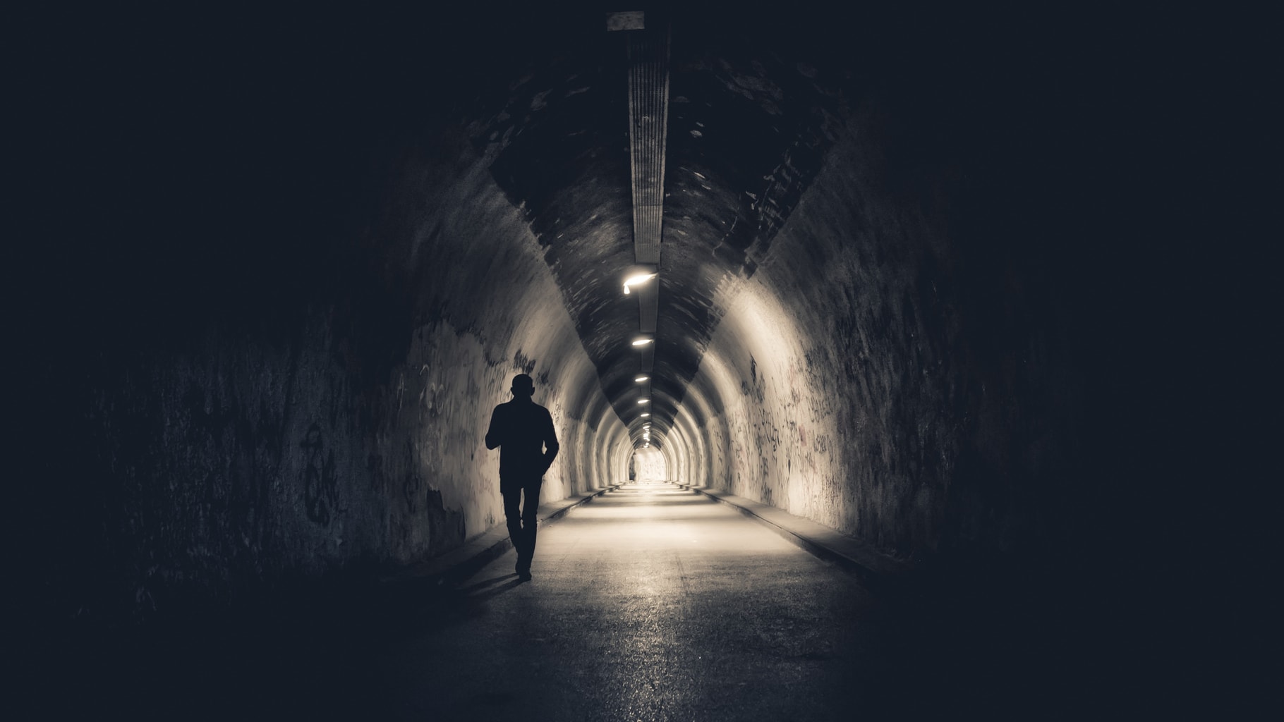 low key photography man in a tunnel