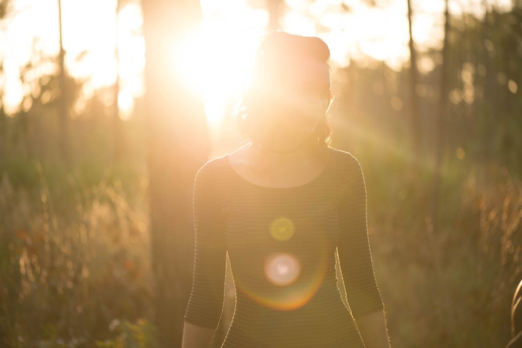 Chica en bosque a contraluz