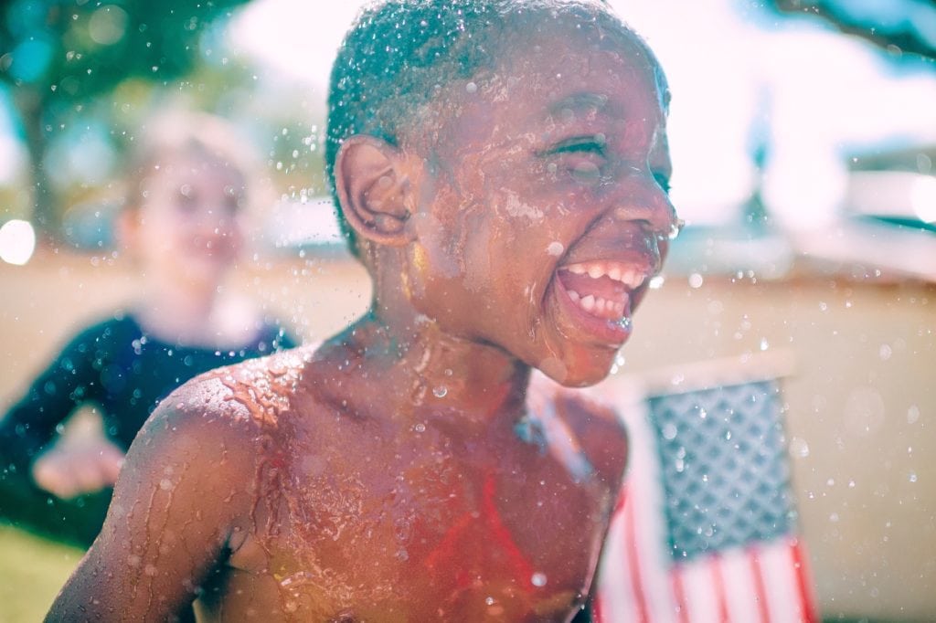 niño riendo con salpicaduras de agua