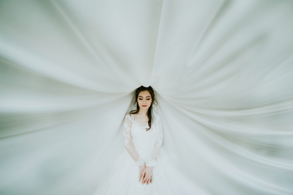 Novia fotografiada con su vestido de fondo. 