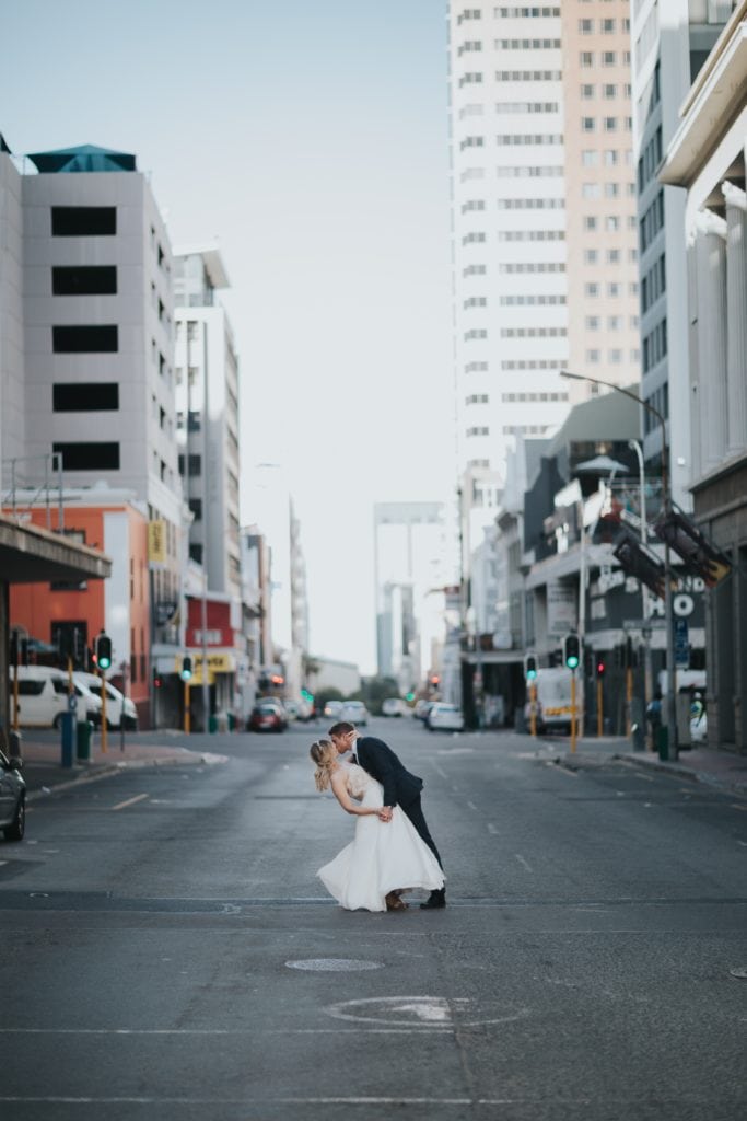 Pareja de novios besándose en medio de la calle