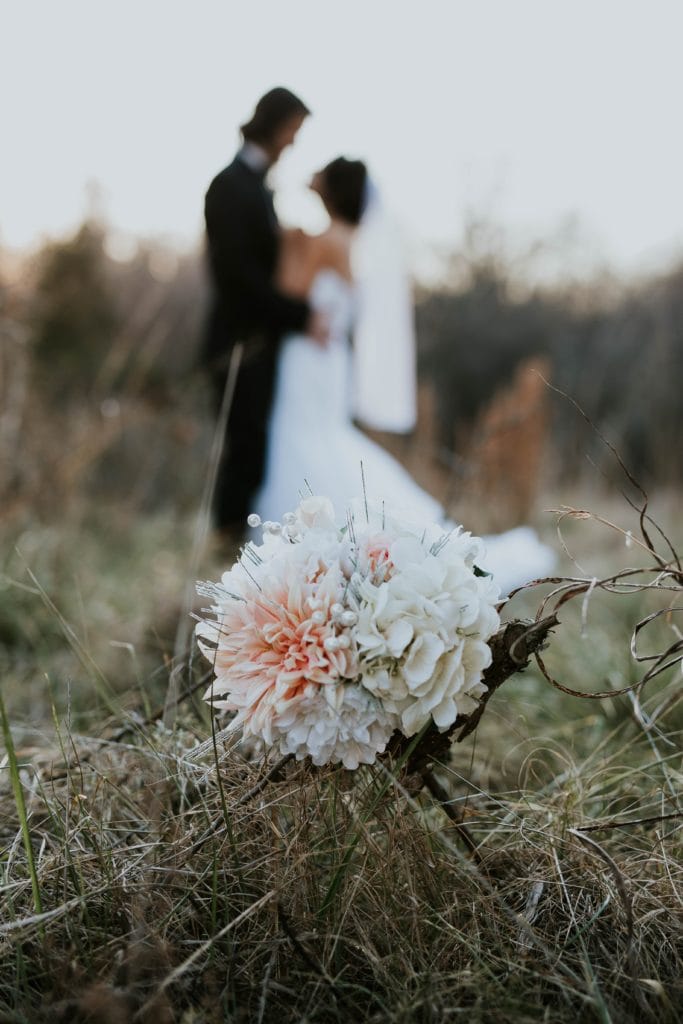 Flores con novios al fondo desenfocados