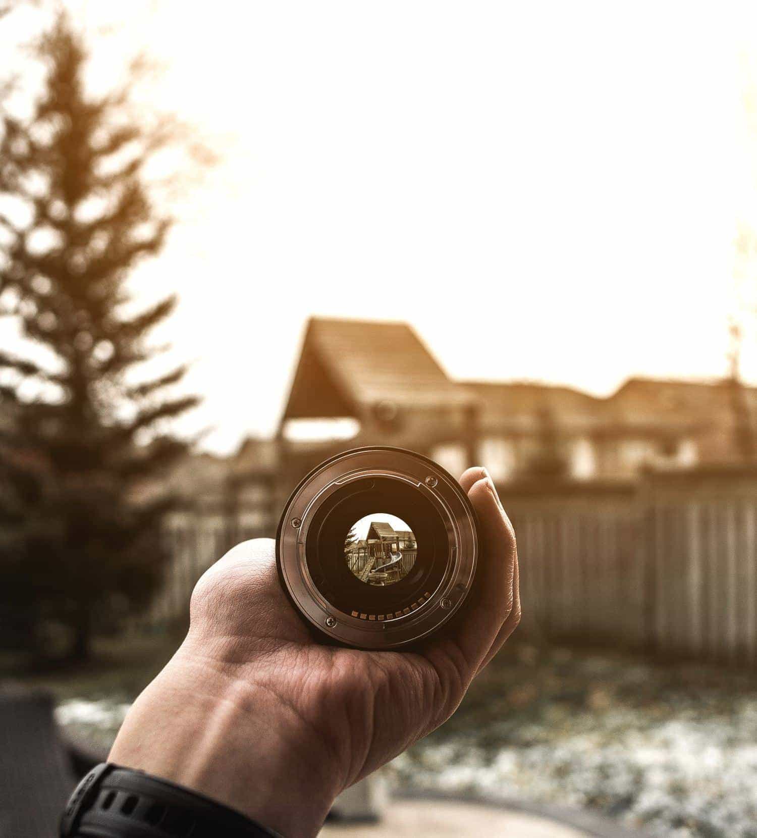 Vista de una casa a través de un objetivo sostenido por una mano