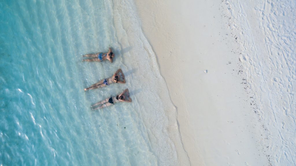 Tres chicas en la orilla playa fotografiadas con un dron