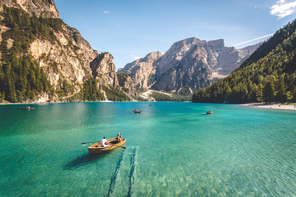 Lago rodeado de montañas con barquitas