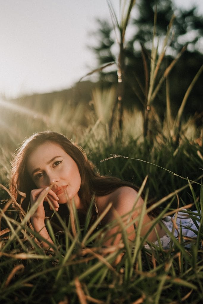 pose lying on grass at sunset