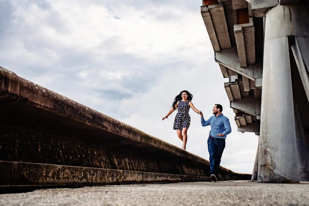 pareja paseando de la mano mientras ella está subida en alto