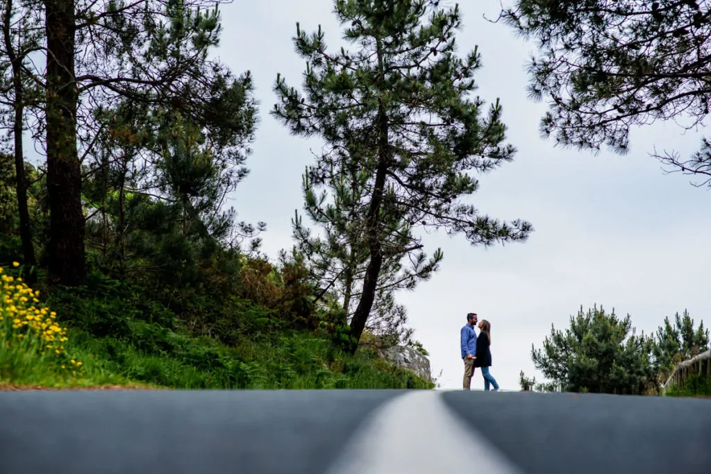 pareja en carretera con bosque de fondo