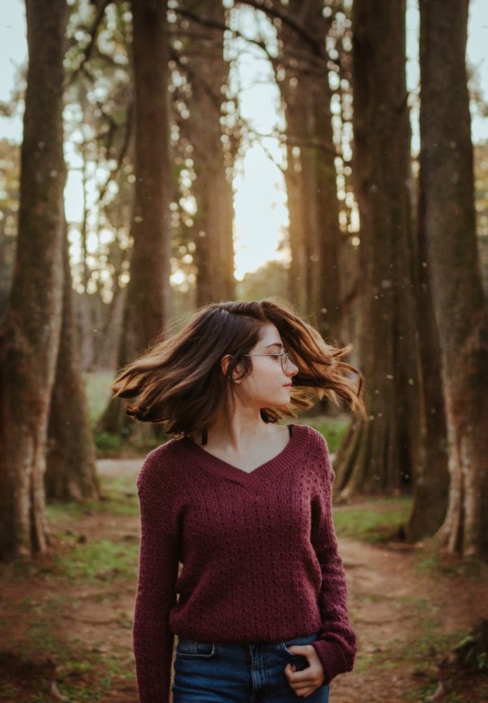 young girl in forest with moving hair