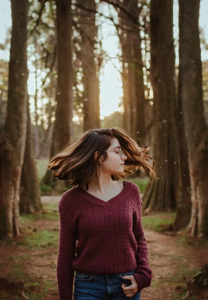 chica joven en bosque con pelo en movimiento