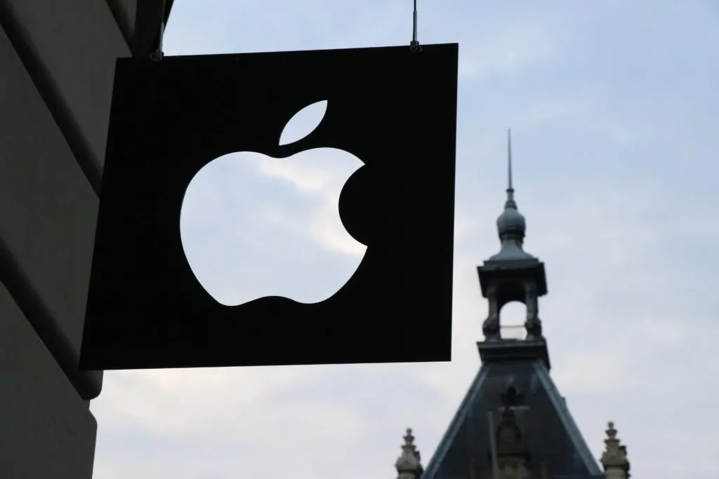 Letrero con logo de apple y torre al fondo