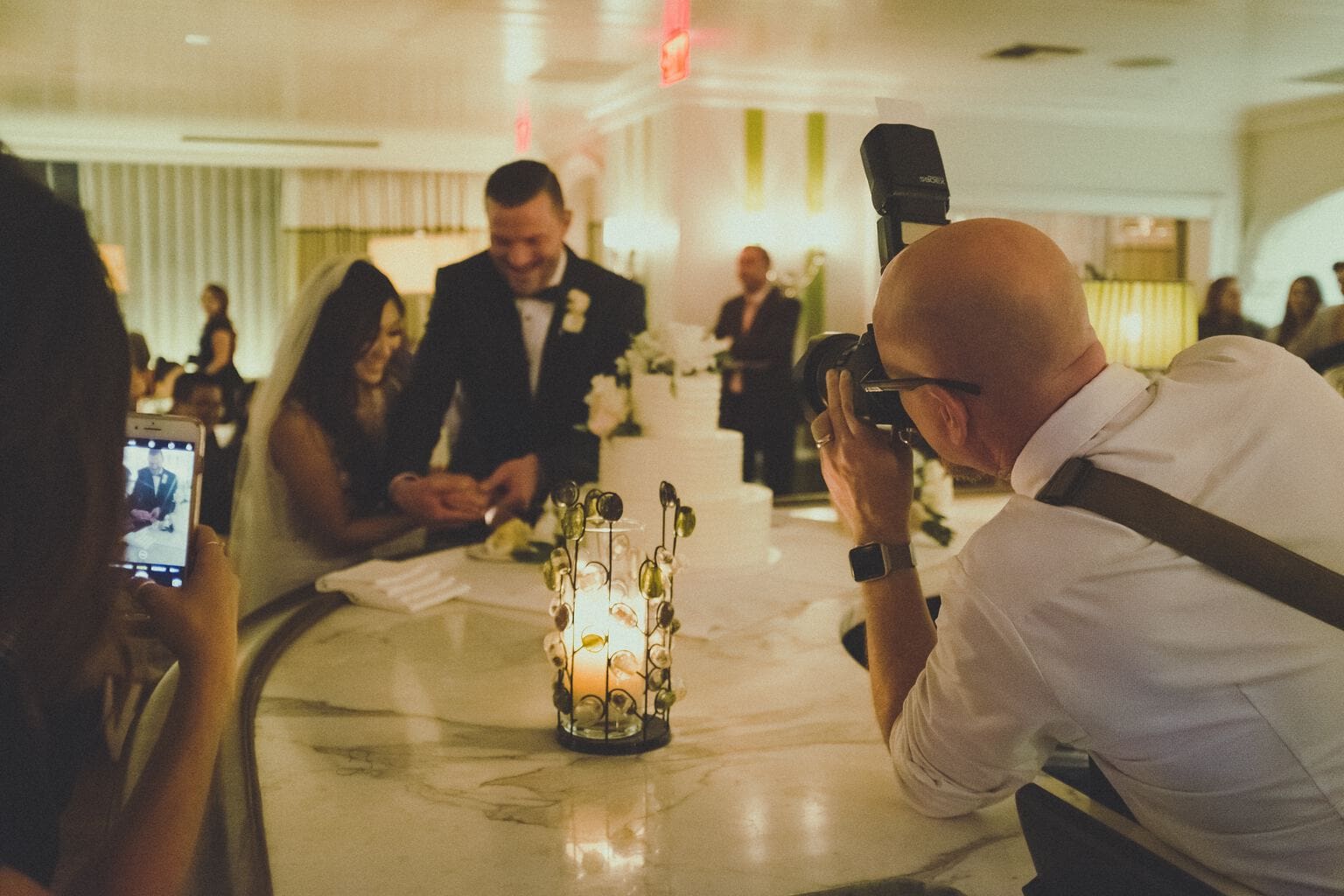 Fotógrafo capturando a los novios cortando la tarta