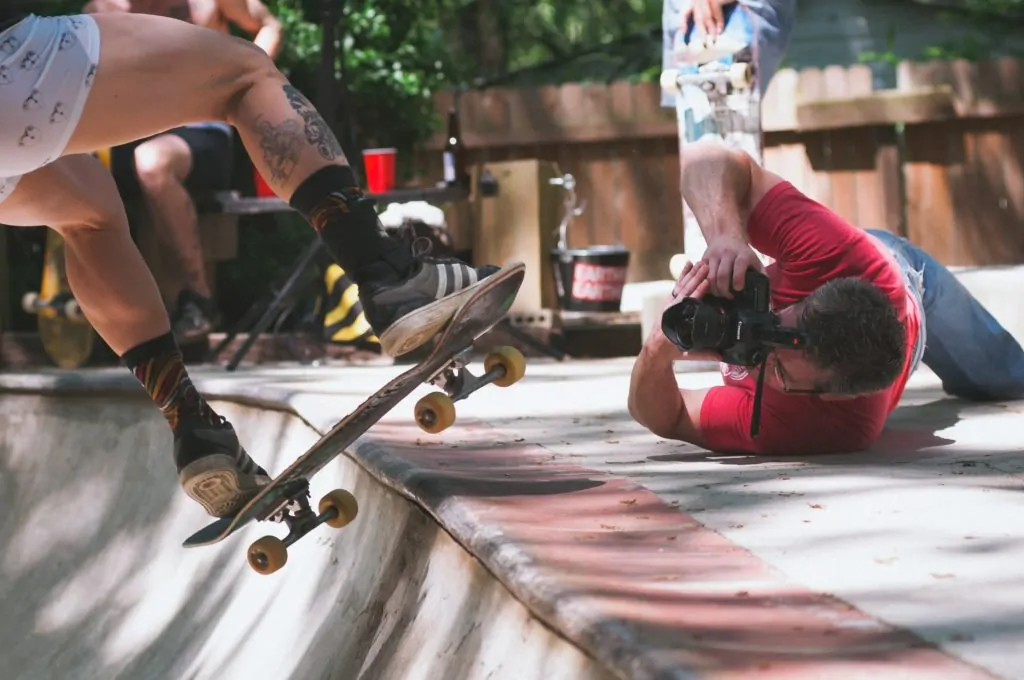 Fotógrafo tumbado en el suelo para fotografiar a un skater