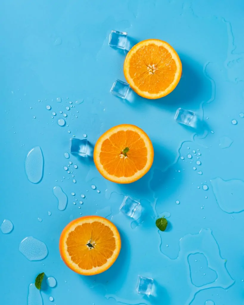 Naranjas sobre fondo azul y hielo