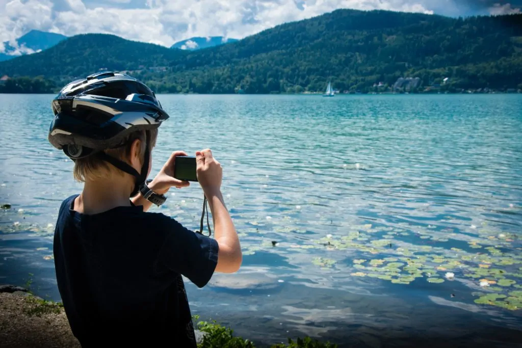 Niño con cámara fotos en lago