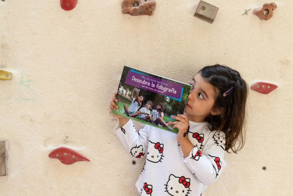 Niña con el libro Descubre la fotografía en las manos