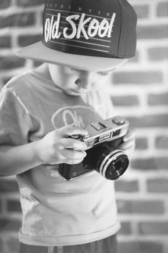 niño con cámara de fotos y gorra