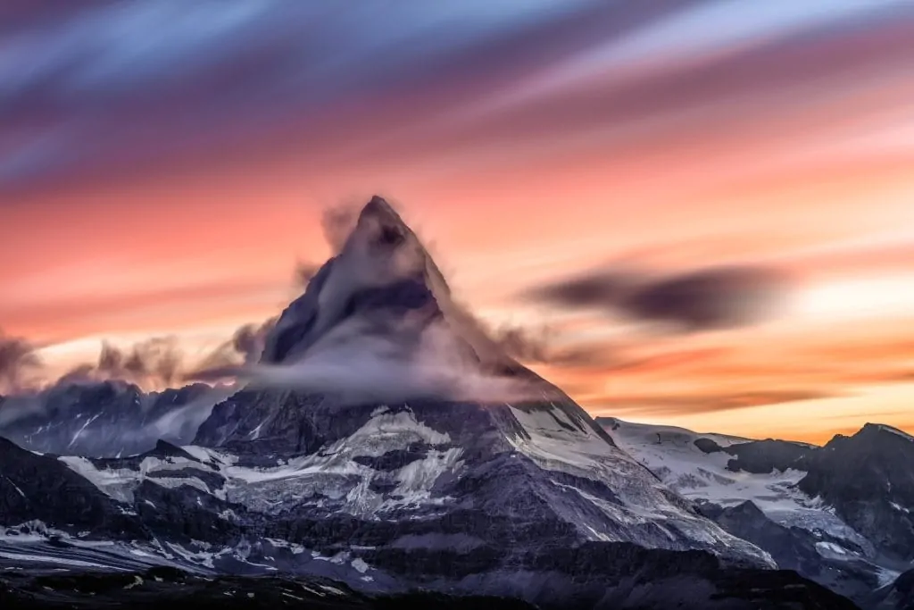 Mountain surrounded by clouds at sunset