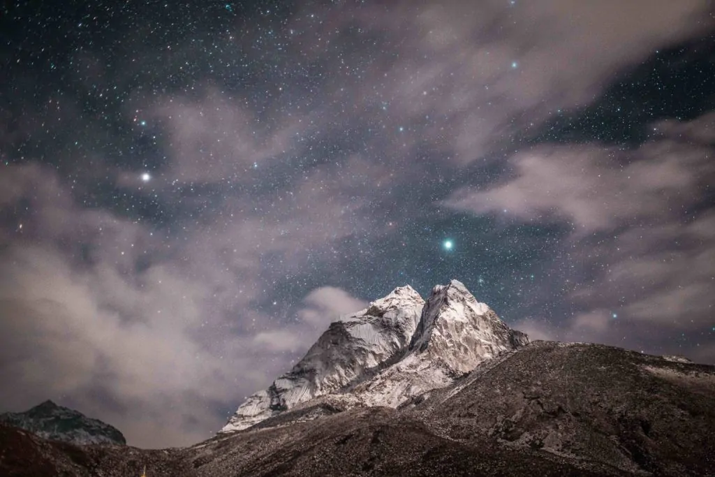 Fotografía de montaña de noche rodeada de estrellas