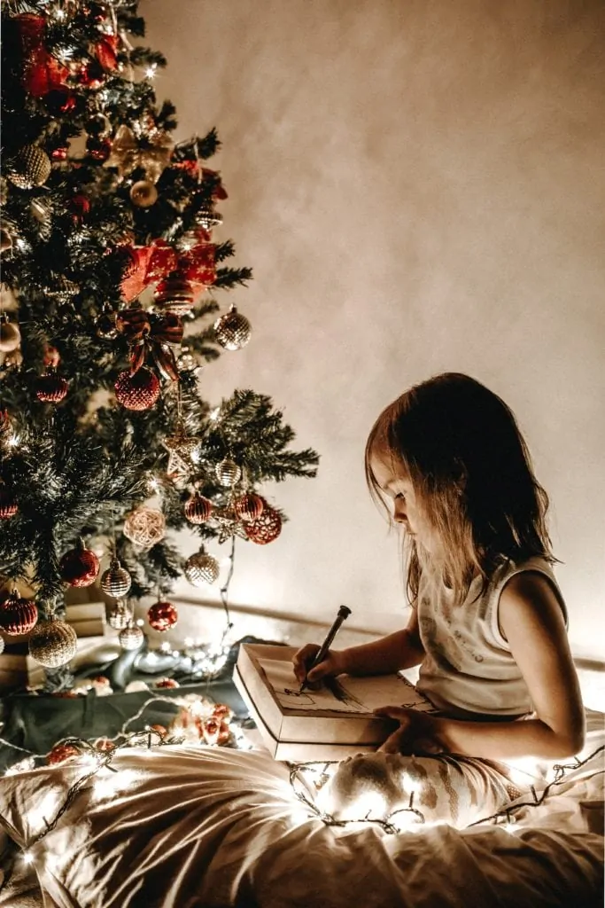 Niña junto a árbol de Navidad