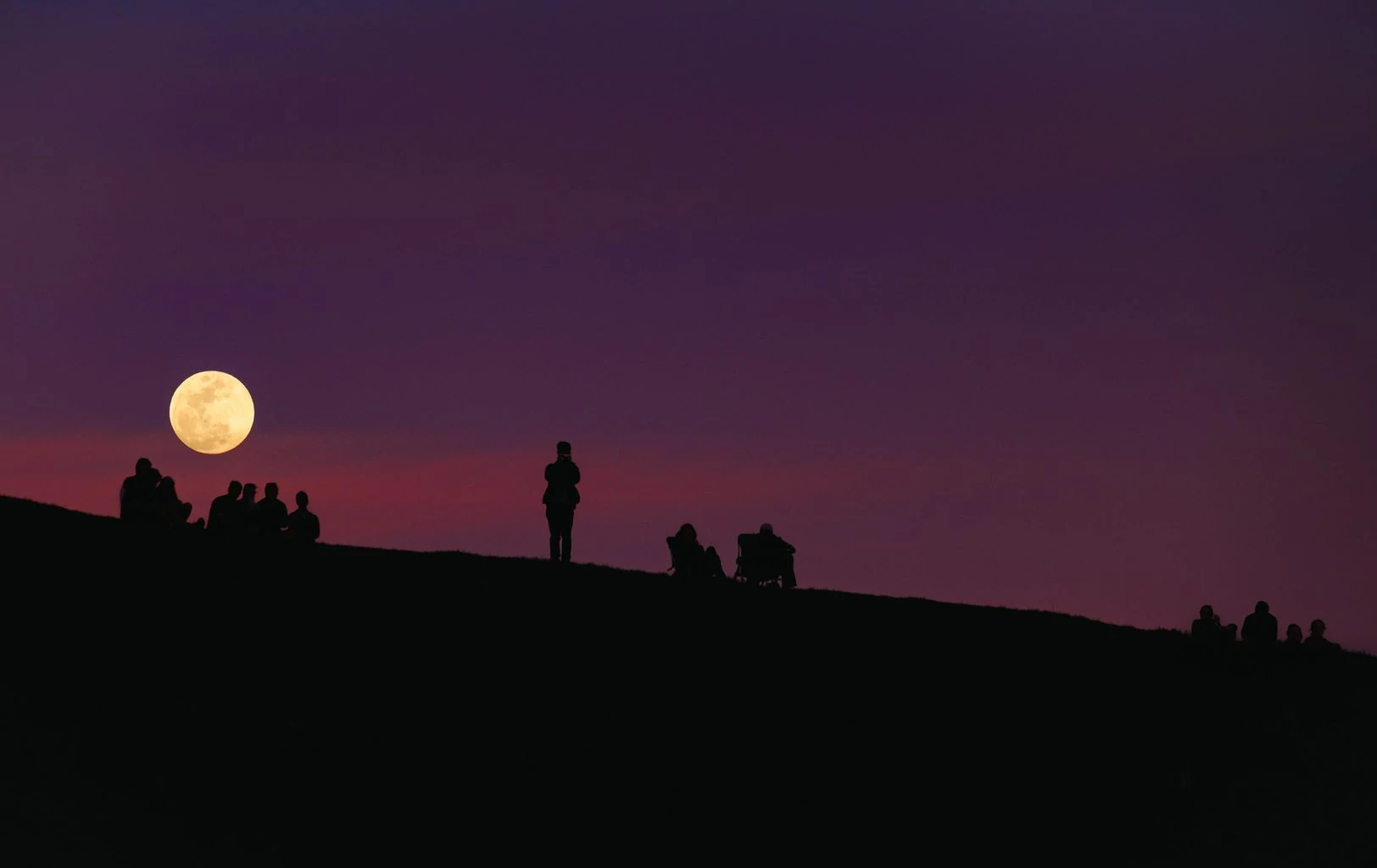 Gente observando y fotografiando la luna