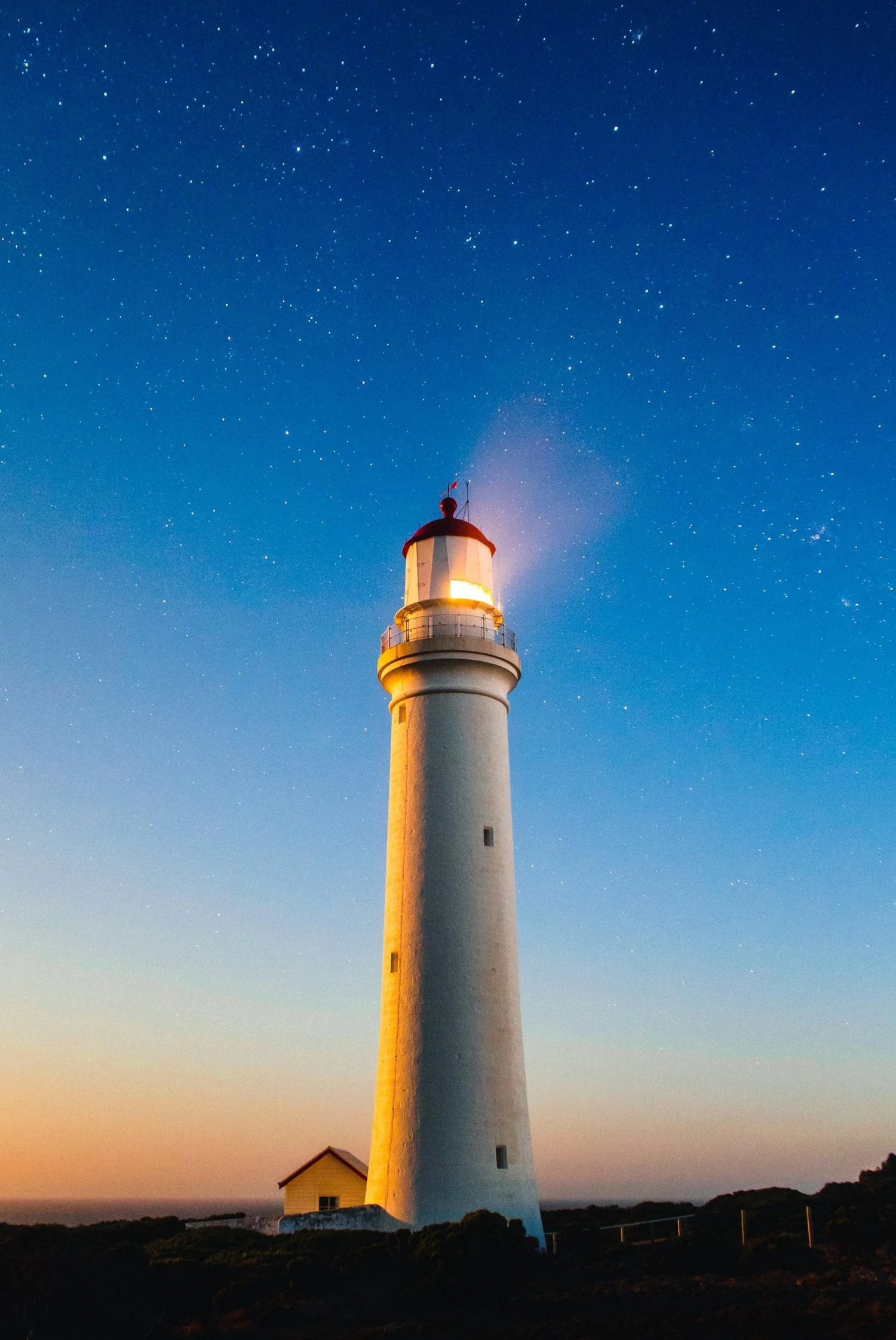 Faro en larga exposición con cielo de estrellas