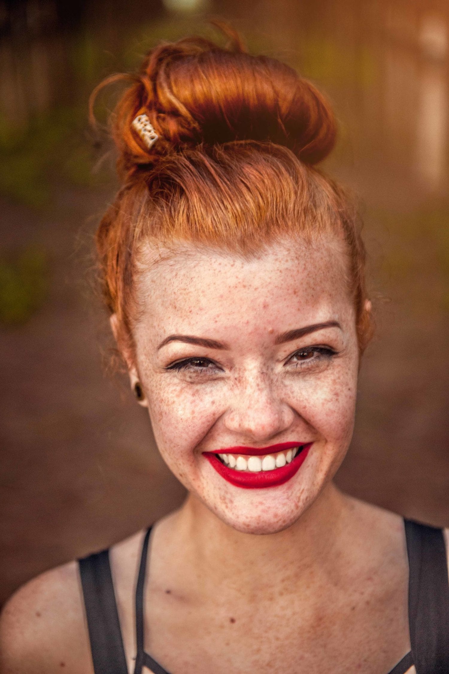 Retrato de chica pelirroja con labios rojos y fondo desenfocado