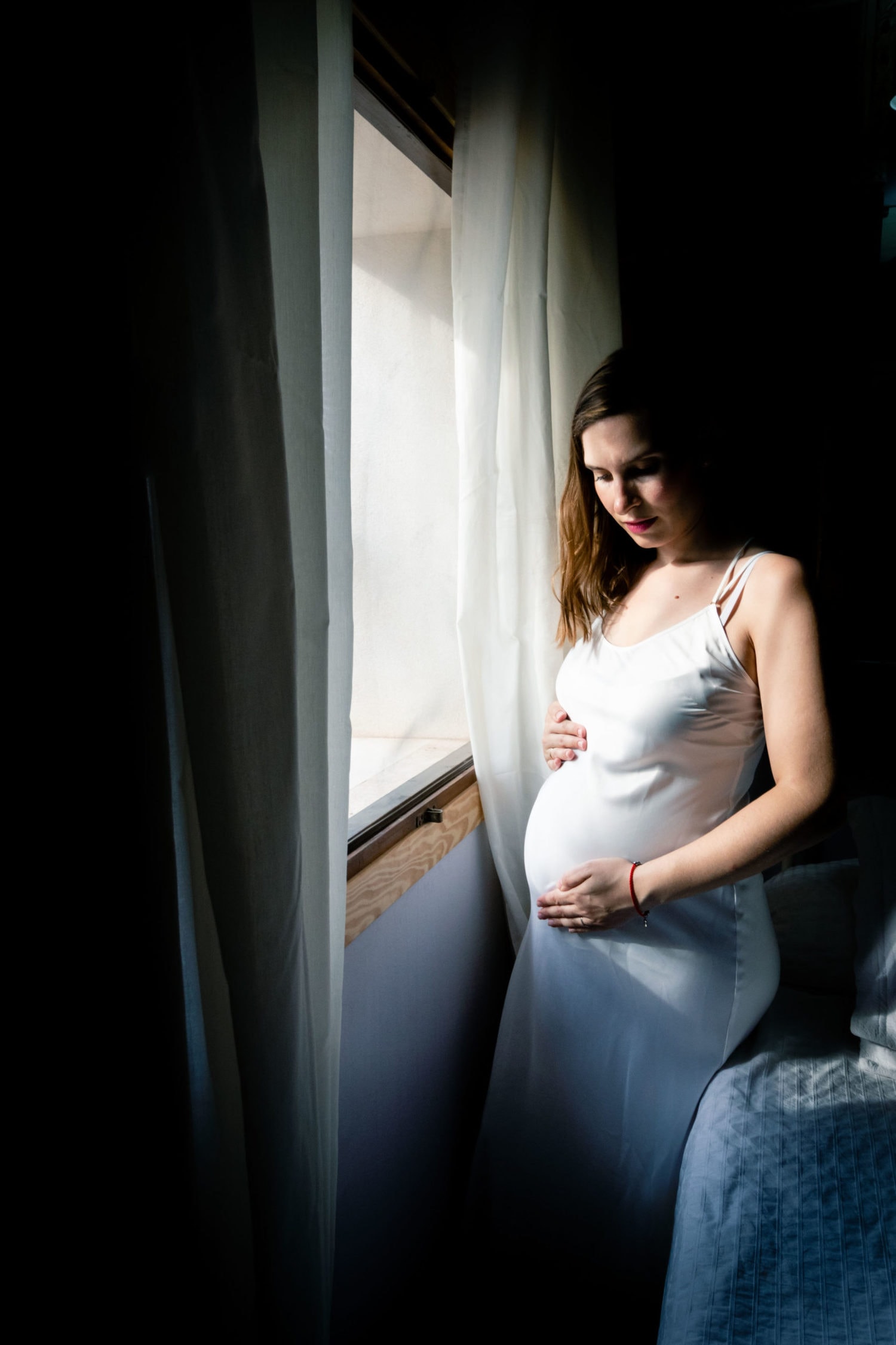 Retrato de mujer embarazada cerca de ventana