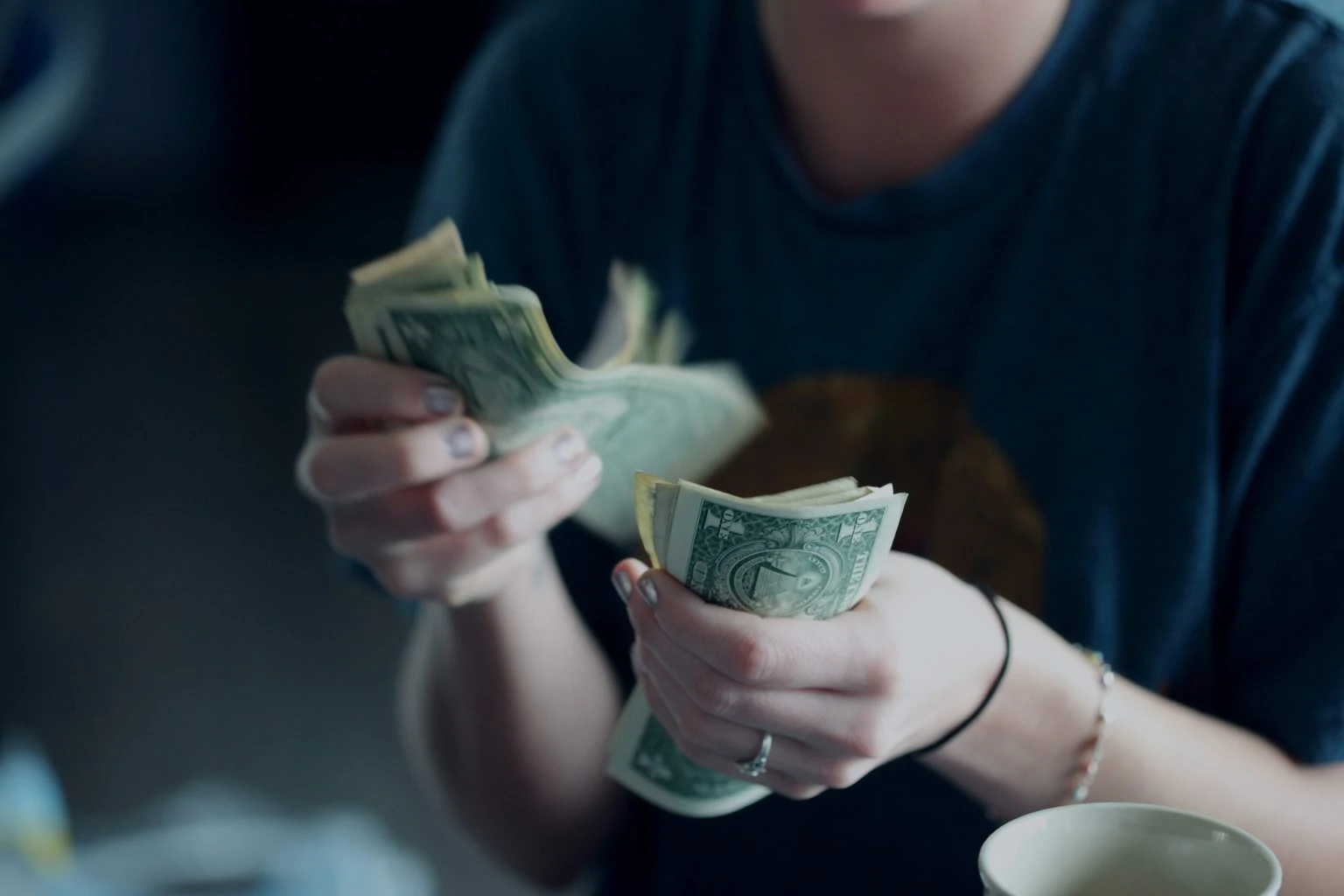 Woman counting dollar bills from selling pictures