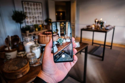 Sosteniendo un Huawei P30 pro en la mano con la vista de cámara enfocando una mesa de comida