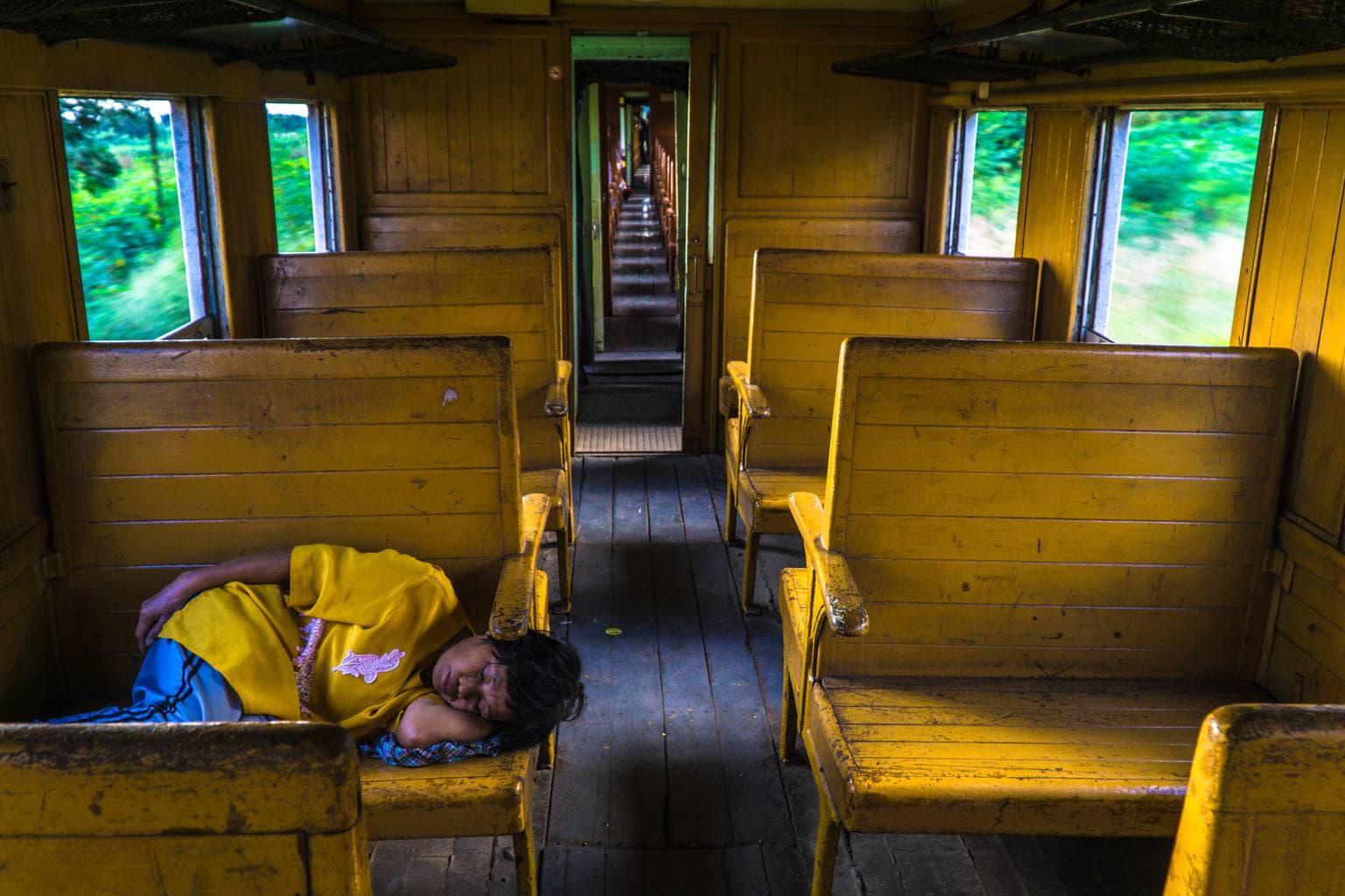 Vagón de tren amarillo con alguien durmiendo la siesta