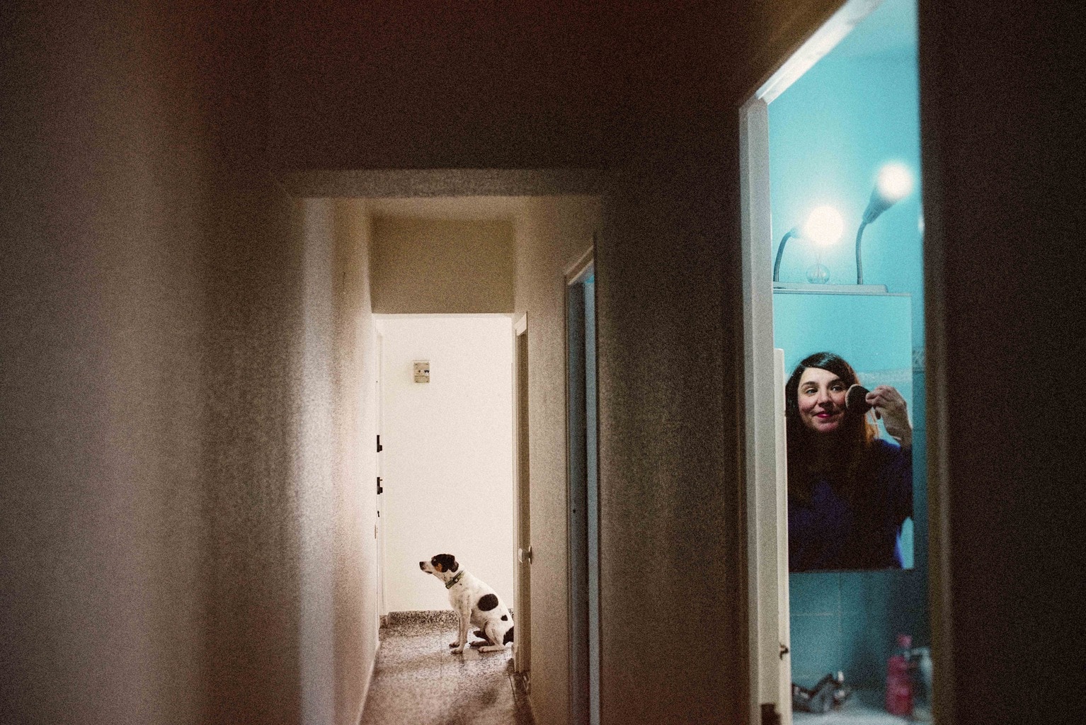 Autorretrato de chica pintándose mientras su perro espera en la puerta para salir