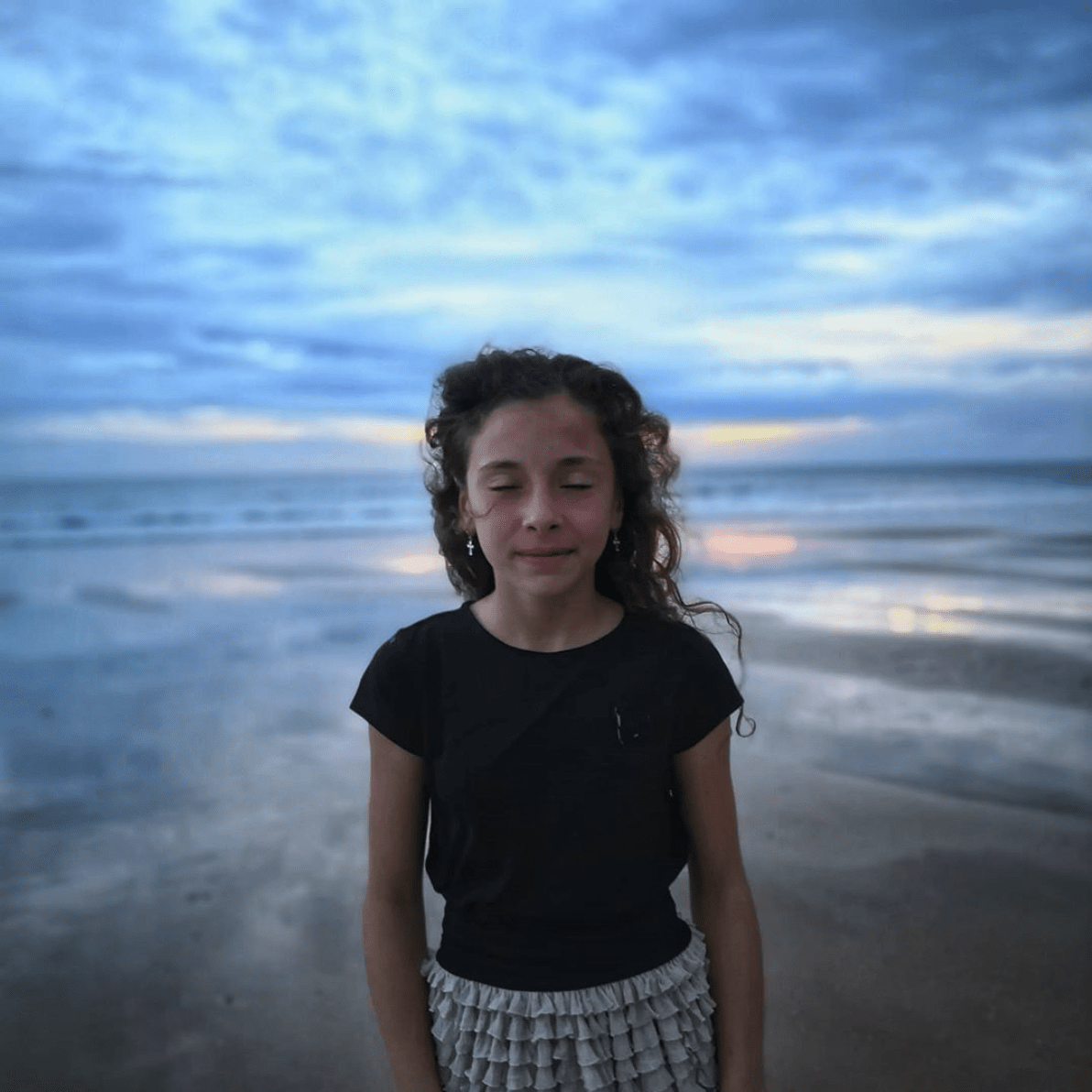 Niña en la orilla de la playa.