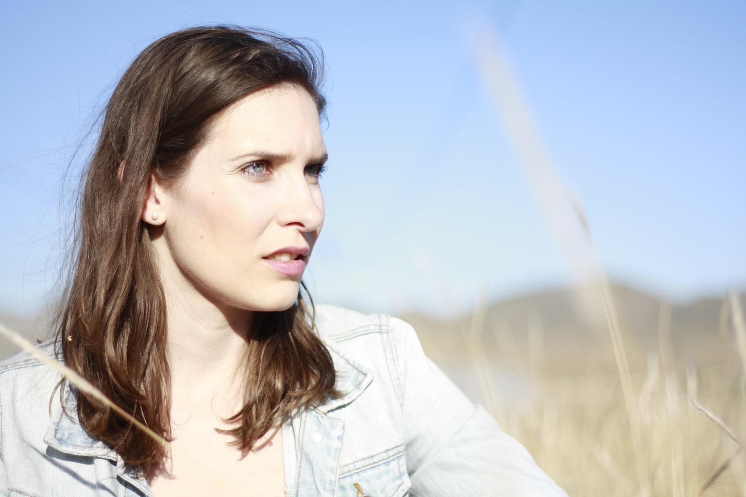 retrato con sol de frente en el que la modelo no está cómoda e intenta no cerrar los ojos