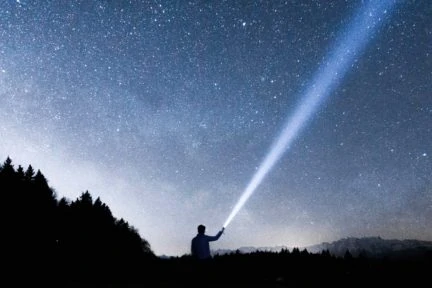 cielo estrellado y silueta con linterna