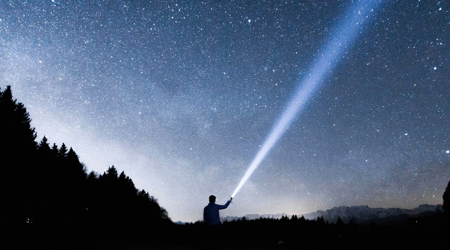 cielo estrellado y silueta con linterna