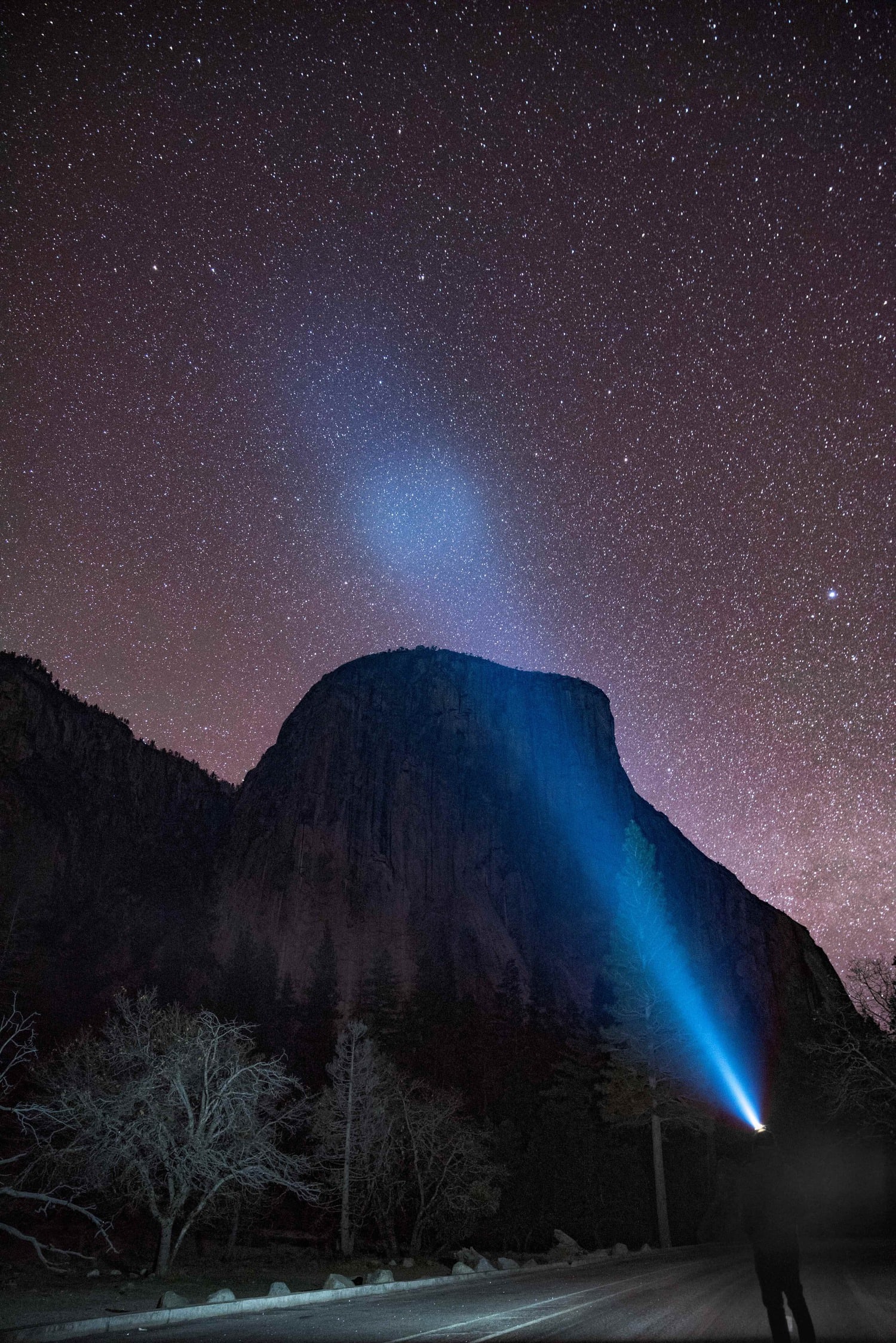 Fotografía nocturna de cielo estrellado con haz de luz de frontal