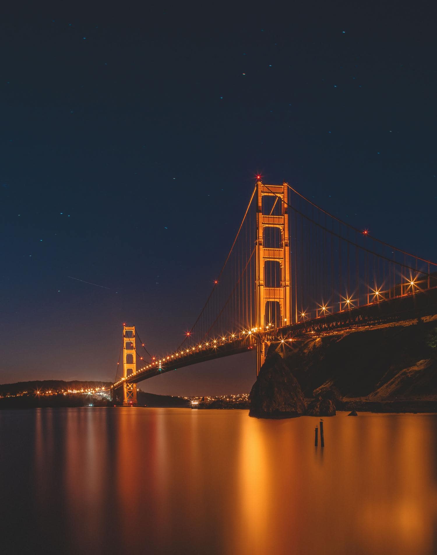 Puente como parte de un paisaje urbano nocturno con luz de farolas en forma de estrella