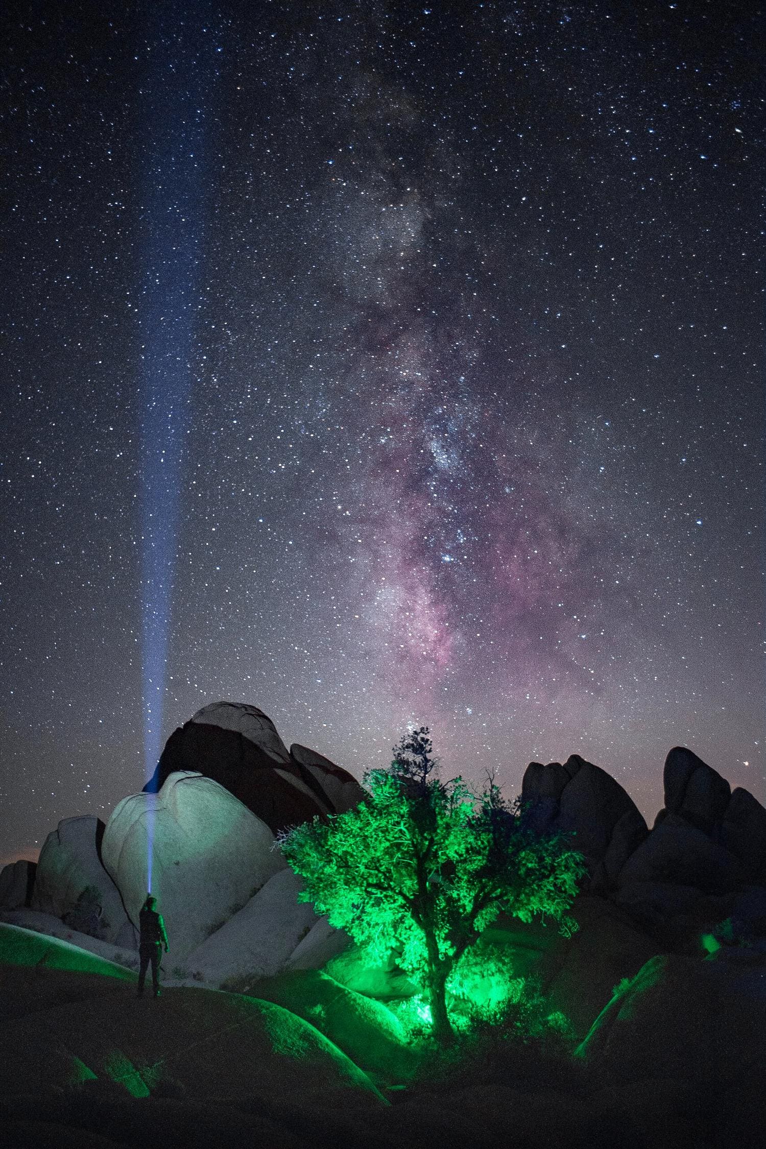 fotografía nocturna de cielo estrellado, haz de luz de linterna y flash con gel de color verde