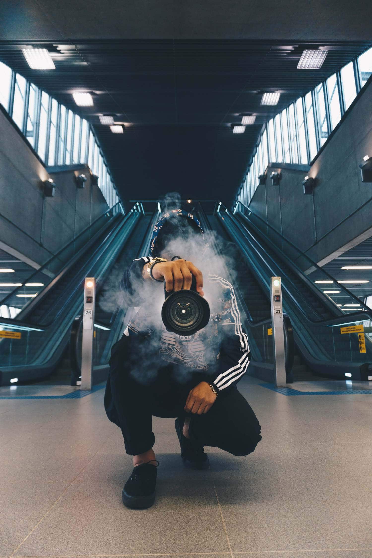 Fotógrafo con cámara en mano echando humo